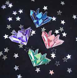 Product photo: enamel pins of kyber crystals in blue, red, purple, and green